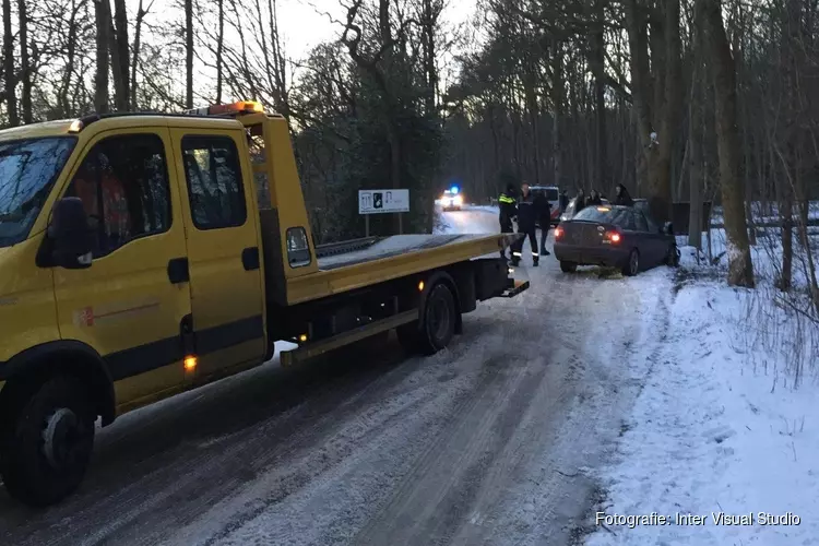 Auto tegen boom gereden door gladheid